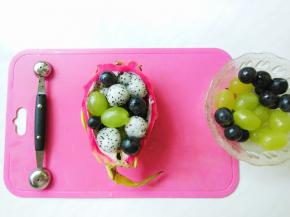 挖好火龙果球后和葡萄、提子混合装入挖空后的火龙果空壳内。