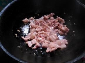 起锅热油，放入腌好的肉片煸炒至变色。