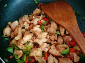 加入炸好的鸡腿肉翻炒，加少许盐、鸡精调味