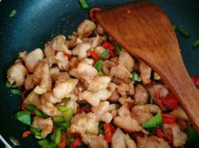 加入炸好的鸡腿肉翻炒，加少许盐、鸡精调味