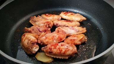 锅中放油，放入鸡翅煎至表面成焦色。