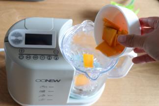 安装好辅食机的搅拌杯，放入蒸篮，倒入南瓜片；