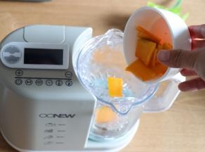 安装好辅食机的搅拌杯，放入蒸篮，倒入南瓜片；