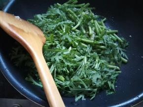 先放入茼蒿根部的梗，再放入叶子。