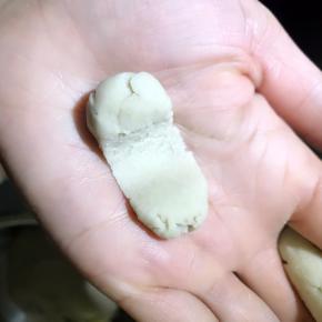 5.取一小点面放于手掌，用右手拇指中间推压一下