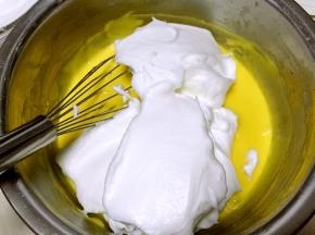 将打发好的蛋白分次加入到蛋黄糊中翻拌均匀