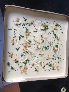 用刮刀摊平，捏着金盘两角晃动，面糊会变平，撒上肉松，葱花，芝麻，肉松轻轻压一下