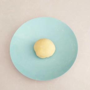 加入适量清水，揉成较硬性的面团，盖上保鲜膜醒发20分钟。