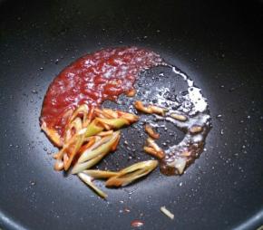 留余油，下葱花姜丝爆香，下番茄酱炒匀。