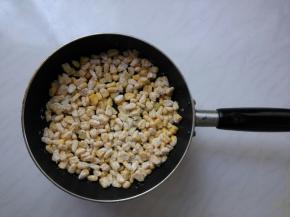 放入玉米粒，使玉米粒平铺锅底。