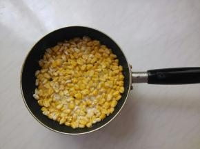 先中火慢煎，定型阶段，别动玉米粒。过一会定型了，晃动锅时玉米能整体移动了，说明底部粘连好了。