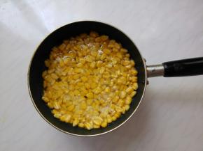 中间如果有开裂的可以调一点点的水淀粉，补缝，不能多了，就不脆了。然后倒入能没过玉米粒的油，再小伙慢煎，用锅铲压一压玉米。