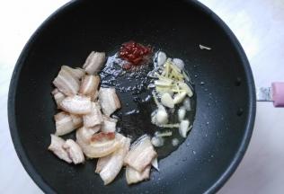 肉片稍微卷略焦，放入姜蒜爆香，再放入豆瓣酱炒香。
