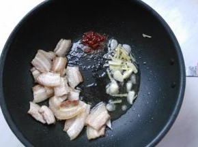 肉片稍微卷略焦，放入姜蒜爆香，再放入豆瓣酱炒香。