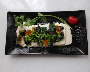 皮蛋碎放在豆腐上，撒上香葱末。