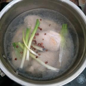 鸡腿入锅，加葱段姜片和花椒煮熟，捞出泡在冰水里(冰水是开水提前放凉放冰箱冷藏)