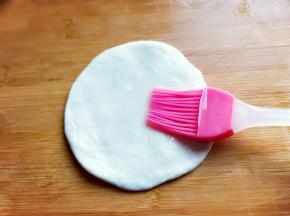 再擀开的面片表面刷上一层植物油。