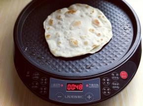 盖上电饼铛盖，不需要调火力，保持预热时候的“速脆”火力。选择自主烙饼，1分15秒左右即可。将烙好的饼取出，依次做完。