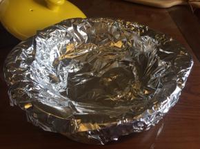 在烤架上面，用锡纸把砂锅的边缘都包围起来，用两张锡纸，“十”字交叉，把砂锅包好，这样烤的时候，水分才不会流到砂锅的底部；