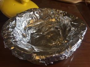 在烤架上面，用锡纸把砂锅的边缘都包围起来，用两张锡纸，“十”字交叉，把砂锅包好，这样烤的时候，水分才不会流到砂锅的底部；