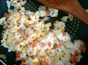 加入米饭和鸡蛋炒匀，加几滴宝宝酱油调味，再放少许葱花炒匀