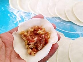 取一个饺子皮，中间放馅。