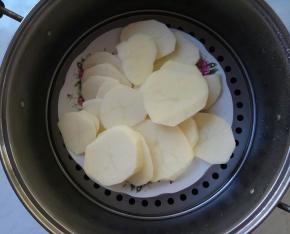 土豆切成薄片，置于平盘中，放入蒸锅里隔水蒸十五分钟。