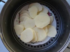 土豆切成薄片，置于平盘中，放入蒸锅里隔水蒸十五分钟。