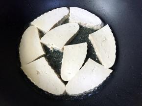 放入豆腐块煎制。
