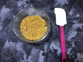 融化的黄油倒入饼干碎中，搅拌均匀。