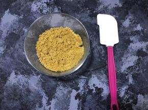 融化的黄油倒入饼干碎中，搅拌均匀。