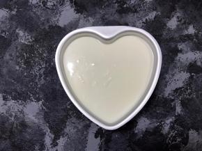 混合好的酸奶糊倒冷藏过的饼干底模具中，轻磕2下，震出里面的大气泡后放入冰箱，冷藏4小时。