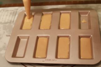 烤箱预热185度。将面糊挤入费南雪模具内，7分满