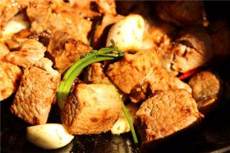 炒锅加油，下入香菜根、姜片、葱段、大蒜、花椒和干辣椒炒出香味，再加入豆瓣酱炒香，下入牛腩炒匀。