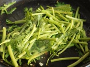 茼蒿洗净，取杆部。刚才煎虾的锅，爆香蒜末，下入茼蒿翻炒。