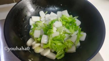 加入适量的清水炒制年糕变软，要不停的翻炒，避免年糕粘锅