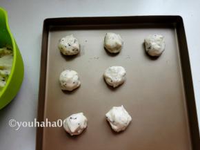 面团有点沾手，可以在手上抹一点油，分成25克一个的面团，大致搓圆摆放在烤盘中，放置15分钟左右