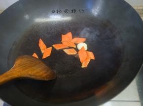热锅冷油加入拍扁的大蒜还有胡萝卜翻炒