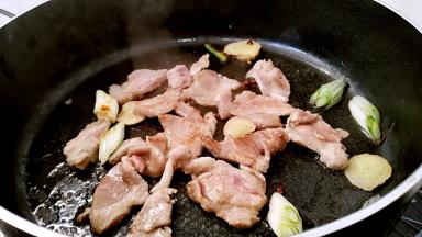 放入肉片小火煎至变色。