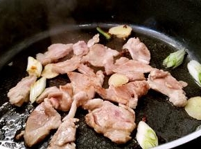 放入肉片小火煎至变色。