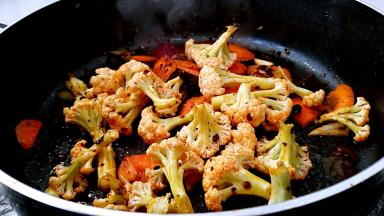 倒入菜花和胡萝卜转中火煸炒十几下。