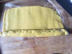 将面皮贴紧馅料卷起一圈，在接合处切开断，包好馅料的面皮接口处捏合。