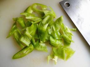 2.	尖椒清洗干净，去蒂后，切成片，培根比较长，横着切几刀即可，