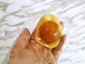 饼皮压扁，包住馅料，虎口收口