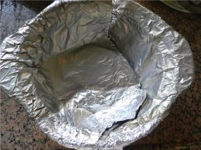 在锅里铺上3张交叠的锡纸，贴紧砂锅内壁，一定要将锡纸延到锅外来，这样才不会滴水或滴糖到锅里（顶部多出的的部分包住锅的边沿）。