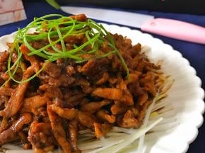 把切成细丝的葱白铺在盘子底部，放上炒好的肉丝，再把葱绿丝撒在肉丝上。