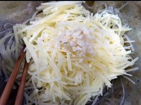 过凉的土豆丝沥干水放入盆里，加入上步做好的蒜油