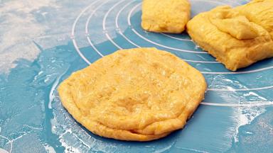 取一个剂子按扁，在对折两下，最后要均匀的按扁，四周薄，中间要很厚的状态。