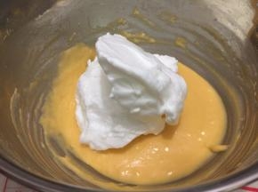 将1/2的蛋白霜倒入蛋黄糊中，用手动打蛋器从盆底由下向上快速翻拌（不习惯用手动打蛋器的朋友请用硅胶刀