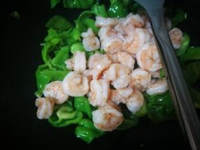 青椒炒至变色，倒入虾仁